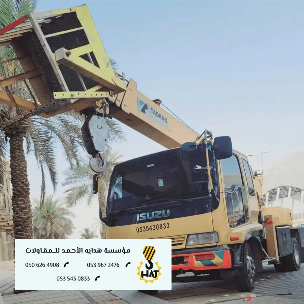 كرين ضخم (رافعة) يقوم برفع حمولة ثقيلة على سطحة في موقع إنشاء بالرياض