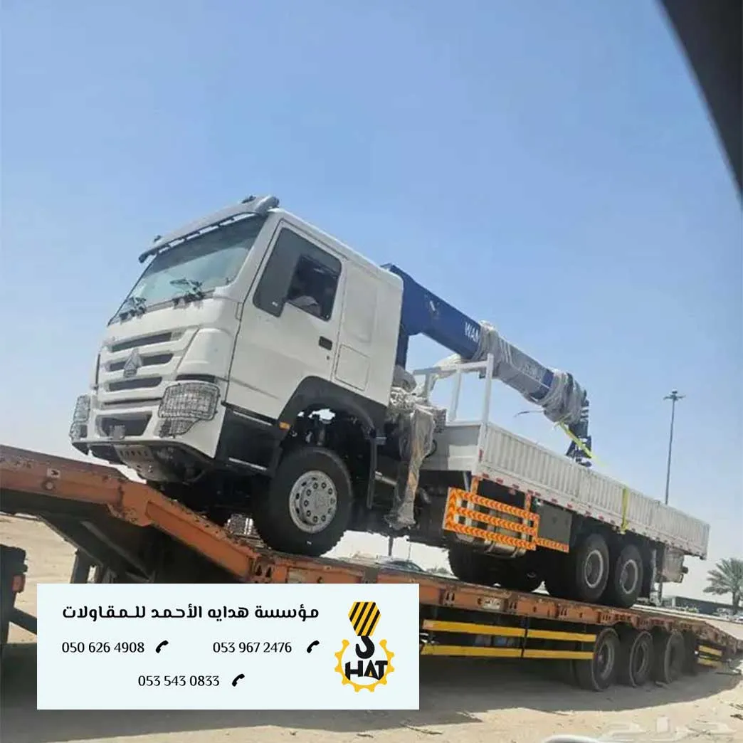 سطحة نقل ثقيل تحمل معدة ضخمة تسير على طريق سريع