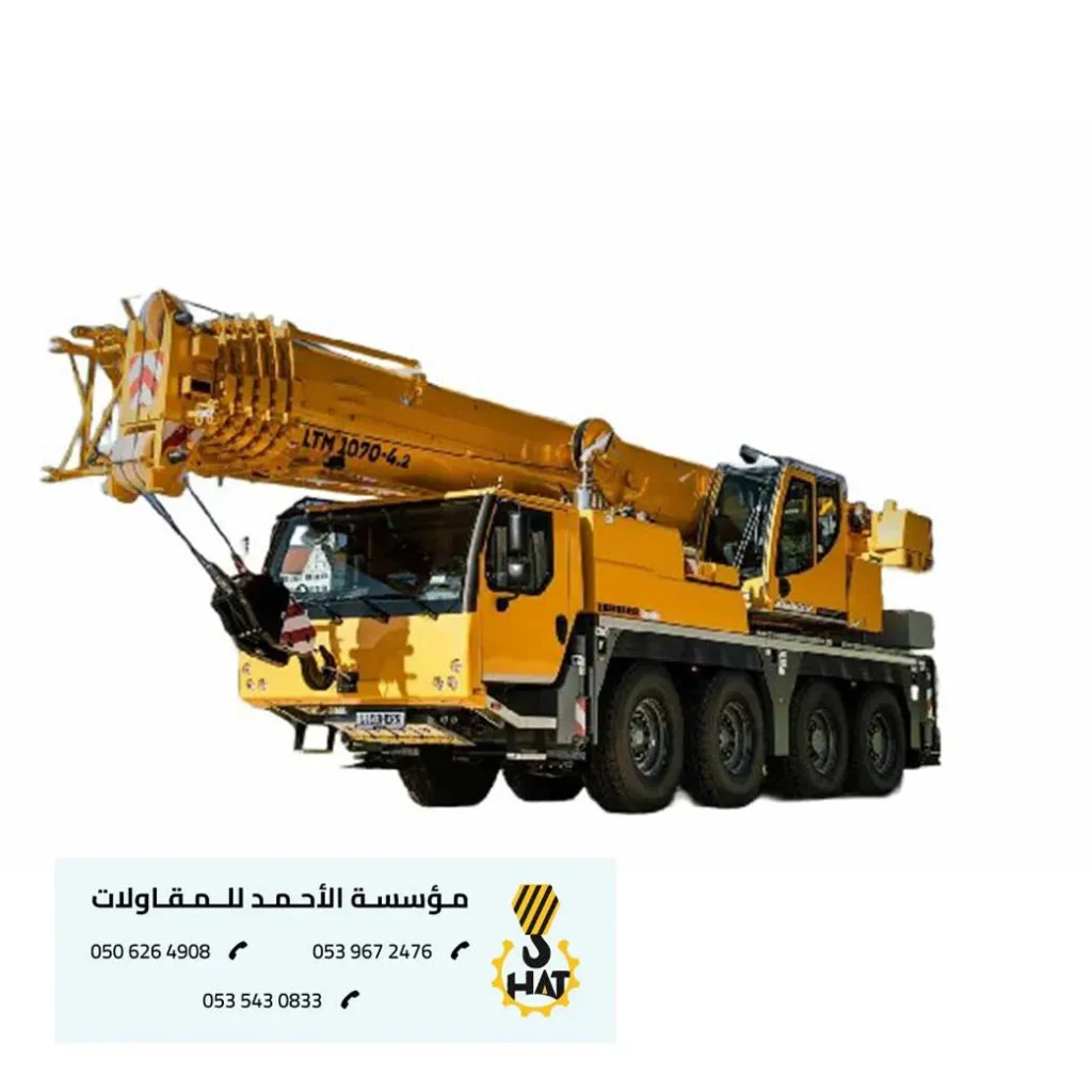 فني صيانة يقوم بإصلاح جزء من كرين (رافعة) في الليل مع إضاءة ساطعة